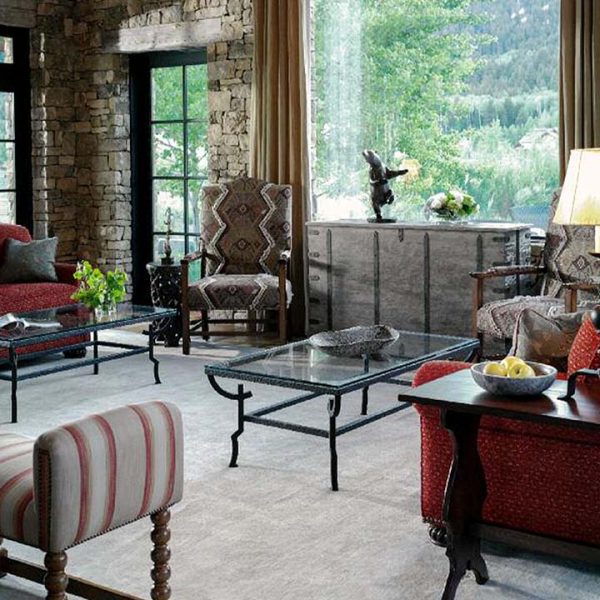 Michael Trent Coates showroom photo of traditional living room with red couch, glass table and side chairs.
